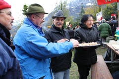 Spezialitäten werden ausgetauscht: Stefan Fässler (links) und Ernst Jakober (Mitte) von den Stadtschützen Glarus genehmigen sich ein Häppli von den Auslandschweizern.. (Bild: Irene Infanger / Neue SZ)