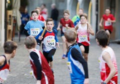 kinder und Erwachsene laufen durch die Zuger Altstadt, beobachtet von Hunderten Zuschauern. (Bild: Stefan Kaiser (Zuger Zeitung))