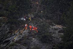 Geologen begutachten die Felswand oberhalb des SBB-Gleises. (Bild: Keystone)