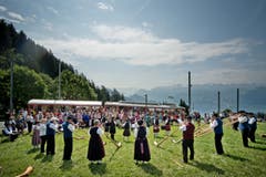 Auf dem Bild zu sehen ist das Alphornensemble mit Pipes und Drums vor der einfahrenden Rigi-Bahn. (Bild: Pius Amrein (Neue LZ))