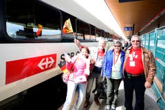 Gewinner einer Fahrkarte für die Mitfahrt im ersten Passagierzug durch den Tunnel steigen ein. (Bild: Keystone / Urs Flüeler)