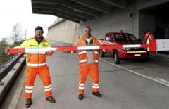Der Verantwortliche des Kantons Uri, Werner Gnos (links) und sein Tessiner Assistent Alfio Curti, öffnen eine Barriere oberhalb von Airolo. (Bild: Keystone)