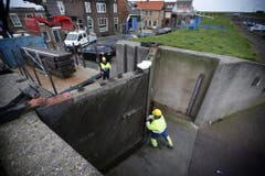 Im niederländischen Den Oever schliessen Arbeiter vorsichtshalber die Tore der Deiche. (Bild: Keystone)