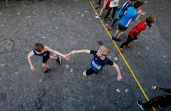 kinder und Erwachsene laufen durch die Zuger Altstadt, beobachtet von Hunderten Zuschauern. (Bild: Stefan Kaiser (Zuger Zeitung))