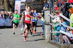 kinder und Erwachsene laufen durch die Zuger Altstadt, beobachtet von Hunderten Zuschauern. (Bild: Stefan Kaiser (Zuger Zeitung))