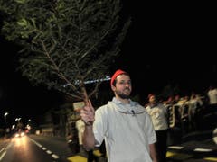 In weissen Hirtenhemden und mit roten Zipfelmützen zogen am Dienstagabend rund dreissig so genannte Greifler durch Sisikon, ... (Bild: Urs Hanhart / Neue UZ)