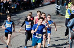 kinder und Erwachsene laufen durch die Zuger Altstadt, beobachtet von Hunderten Zuschauern. (Bild: Stefan Kaiser (Zuger Zeitung))