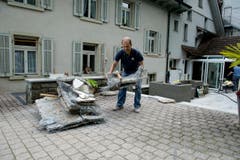 Mitarbeiter der Bäckerei Brunner sind auch eineinhalb Wochen nach der Verwüstung mit Aufräumarbeiten beschäftigt. (Bild: Dominik Wunderli (Neue LZ))