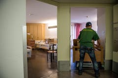 Männer von der Umzugsfirma bringen das Bett eines Bewohners an seinen Bestimmungsort. (Bild: Roger Grütter / Neue LZ)