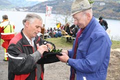 Otto Waser (rechts) vom Seelisberg verteilt seit gut 40 Jahren Stechpalmen als Hutschmuck für die Hüte. (Bild: Irene Infanger / Neue SZ)