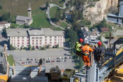 Arbeiter am Mast montieren die grossen vorfabrizierten Teile der Sesselbahn. (Bild: Keystone/Urs Flüeler)