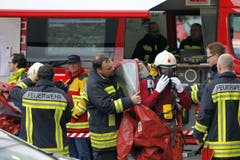 November 2014: Zwei Chemiespezialisten der Feuerwehr Stützpunkt Schwyz werden in einen Vollschutzanzug gekleidet. (Bild: Geri Holdener / Bote.ch)