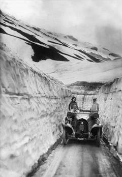Ein Auto fährt im Frühsommer 1914 durch den Schneekorridor der Klausenpasshöhe entgegen. (Bild: Keystone)