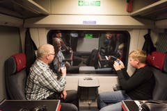 Zwei Premiere-Passagiere sehen nichts durchs Fenster. Da bleibt Zeit für Grüsse aus dem Tunnel. (Bild: Keystone / Epa / Christian Beutler)