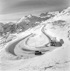 Zwei Fahrzeuge kreuzen sich auf der Südseite am Berninapass, unterhalb der Alp Grüm auf einer Strassenkehre bei winterlichen Verhältnissen, aufgenommen im Dezember 1969. (Bild: Keystone)