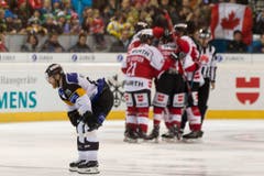Luganos Linus Klasen ist enttäuscht und das Team Canada feiert das 3 zu 1-Goal im Final des Spengler Cup. (Bild: Keystone/ Pascal Muller)
