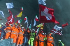 Bauarbeiter feiern den erfolgreichen Durchstoss der Weströhre am Ceneri-Basistunnel. (Bild: Keystone)