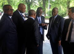 Währenddessen am Mittwoch in Zürich: FIFA-Vizepräsident Issa Hayatou aus Kamerun (dritter von rechts) schaut auf sein Telefon ausserhalb des Hotels. (Bild: AP Photo / Graham Dunbar)