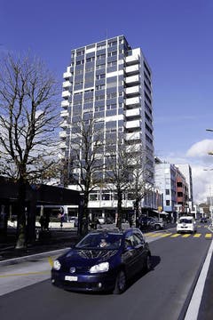 Glashof, Zug Das erste Zuger Hochhaus steht an der Baarer- und der Gubelstrasse und markiert den Kreuzungspunkt. Das Erdgeschoss wird von Läden genutzt und ist damit an den öffentlichen Raum angebunden. Es weist eine Auskragung des Mezzaningeschosses auf, mit Arkade darunter. Das Gebäude ist schön vertikal gegliedert in Sockelgeschoss und Mezzanin - welches nicht nur den Turm, sondern das gesamte Gebäudeensemble optisch «verankert». (Bild: Stefan Kaiser / Neue ZZ)