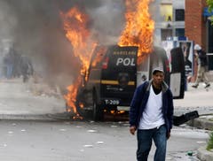 Ein Feuer zerstört ein Polizeifahrzeug. (Bild: AP Photo/Patrick Semansky)