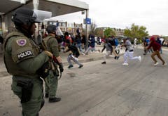 Demonstranten rennen vor Polizisten davon. (Bild: AP Photo / Jose Luis Magana)