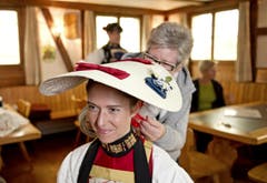 Silvia Käslin zieht Silvia Gut den Kopfschmuck an Im Hintergrund Kobi Würsch. (Bild: Corinne Glanzmann / Neue NZ)