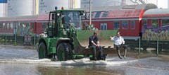 Ein Bagger transportiert Personen durch das Hochwasser in Magdeburg. (Bild: Keystone)