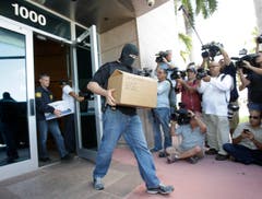 In Miami Beach tragen Bundesbeamte Aktenboxen aus dem Sitz der Nord- und Zentralamerikanischen Konföderation Concacaf. (Bild: AP Photo / Wilfredo Lee)