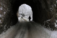 Winter auf dem Balkan: In der Nähe von Sarajewo geht ein Mann auf der verschneiten Strasse durch einen Tunnel. (Bild: AP Photo/Amel Emric)