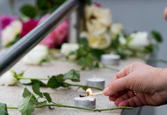Es werden Kerzen angezündet und Blumen niedergelegt. (Bild: AP/Sebastian Widmann)