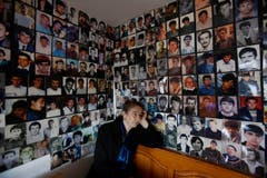 Sonntag, 20. MNärz: Die Bosnierin Habiba Masc vor den Bildern von Opfern des MAssakers von Srebrenica im Sommer 1995. Sie verlor damals ihren Mann Sadija und ihren Sohn Sadmir. (Bild: AP Photo / Amel Emric)