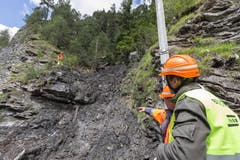 Arbeiter blicken auf die Rüfe über der Ungücksstelle in der Schynschlucht. (Bild: Keystone)