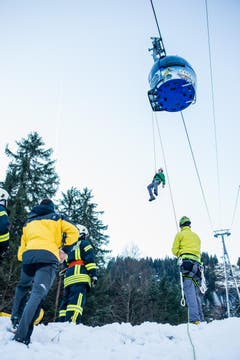 Die aufgebotenen Einsatzkräfte von Bergrettern und Bahnpersonal über Feuerwehrleute bis hin zu Ambulanzen und einem Care-Team – finden weitgehend reale Bedingungen vor. In mehreren Trupps machen sich die Mitglieder der Rettungsstation Sarneraatal zu den Bahnmasten auf, um von dort mittels Klettergurt und Seilen in Schwindel erregender Höhe zu den eingeschlossenen Figuranten vorzudringen. (Bild: Roger Grütter / Neue LZ)
