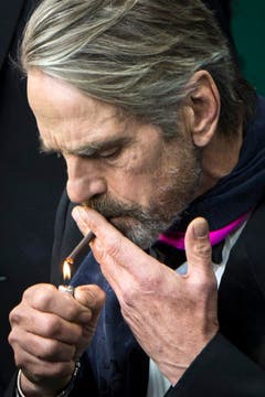 Der Schauspieler Jeremy Irons zündet sich eine Zigarette an. Er kam wegen des Films 'The Man Who Knew Infinity'. (Bild: Keystone)