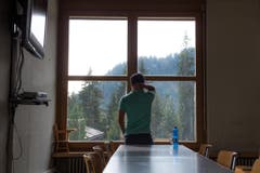Im Speisesaal beobachtet ein Asylsuchender das Treiben auf dem Vorplatz. (Bild: Dominik Wunderli)