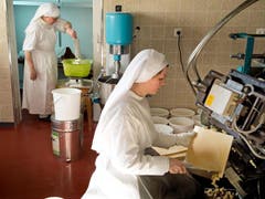 150 Kilogramm Mehl verbacken die Schwestern an einem Tag. In das Wasser giesst Schwester Agnes, hinten, jeweils eine Kanne Wasser aus dem Wallfahrtsort Lourdes, das habe mehr Energie. (Bild: Dominik Wunderli / Neue LZ)