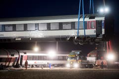 Nach dem Zugunglück mit sechs Verletzten im zürcherischen Rafz werden die Waggons mit einem Pneukran wieder auf die Gleise gehoben. (Bild: Keystone / Ennio Leanza)