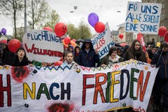 Kundgebungsteilnehmer tragen Transparente am Umzug in Zürich. (Bild: KEYSTONE/Ennio Leanza)