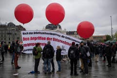 Kundgebungsteilnehmer tragen Transparente und Fahnen am traditionellen 1. Mai-Umzug in Zuerich. (Bild: KEYSTONE/Ennio Leanza)