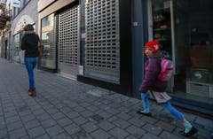 Sie wollte eigentlich in die Schule: Ein Schulkind (mit Schweizer Kappe) geht wieder heim. (Bild: EPA/ Laurent Debrule)