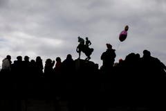 Zuschauer und ein Kind mit einem Ballon beobachten die kostümierten Personen am Umzug "ZüriCarneval 2015". (Bild: ENNIO LEANZA)