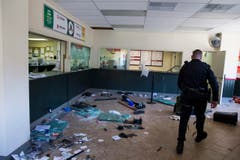 Ein Polizist in einem zertrümmerten Geschäft. (Bild: Keystone / Evan Vucci)