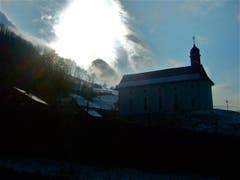 Das Osterlicht bricht durch. Nach einem Tag, an dem es ununterbrochen schneite, brach gegen Abend die Sonne hindurch. Im Bild ist die Ridlikapelle in Beckenried zu sehen. (Bild: Regula Aeppli)