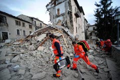 Helfer suchen in Arcuata del Tronto nach Verschütteten. (Bild: AP / Sandro Perozzi)