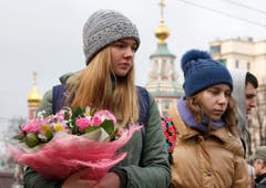 Zwei Frauen mit Blumen vor der französischen Botschaft in Moskau. (Bild: EPA/Sergei Chrikov)