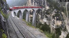 Der Zug der Rhätischen Bahn, der kurz davor vor Tiefencastel entgleiste, kurz vor dem Unglück auf dem Landwasserviadukt zwischen Filisur und Tiefencastel. (Bild: Kurt Caviezel / Webcam RhB)