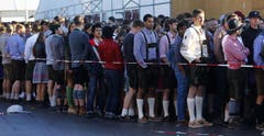 Sie warten auf die Eröffnung: Besucher des 182. Oktoberfestes in München. (Bild: Keystone / Matthias Schrader)