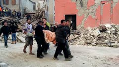 Helfer bergen eines der Opfer in Amatrice. (Bild: AP Photo / Videostill)