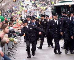 Die Feuerwehrleute grüssen die Zuschauer in Boston. (Bild: Keystone)