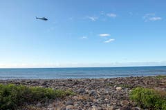 Ein Helikopter bei der Suche weiterer Hinweise über dem Strand von La Réunion. (Bild: Keystone)